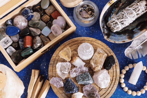 a variety of crystals with palo santo and feather for smudging work