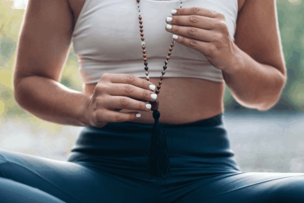 person meditating wearing mala beads
