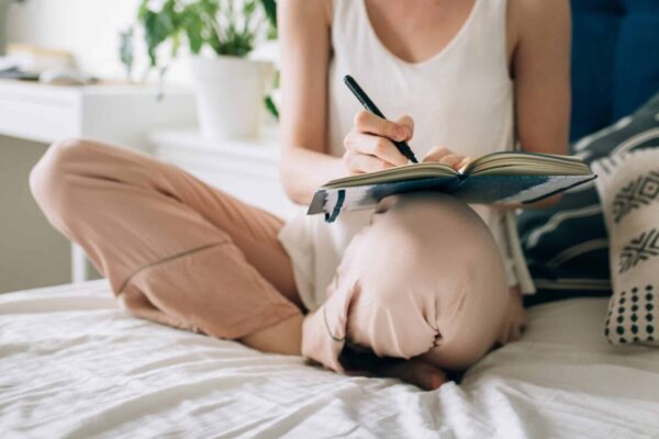 person writing in their journal and doing some personal scheduling