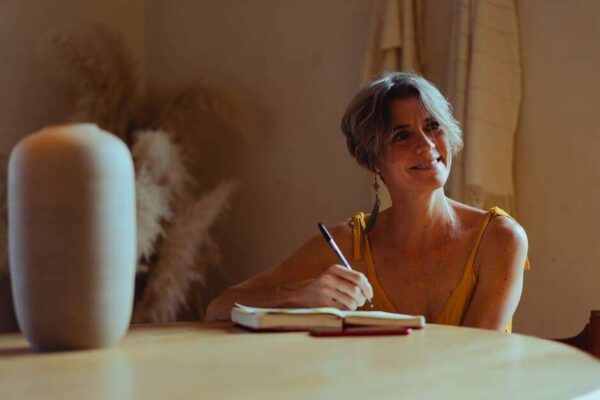 person sitting at table with a pen and journaling