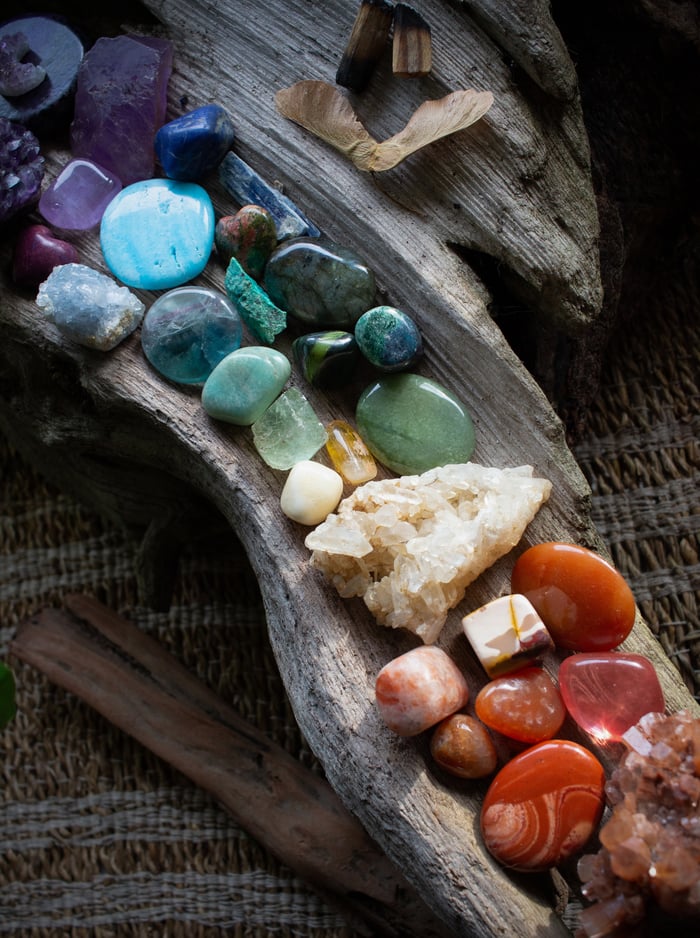 crystals and stones on a piece of driftwood