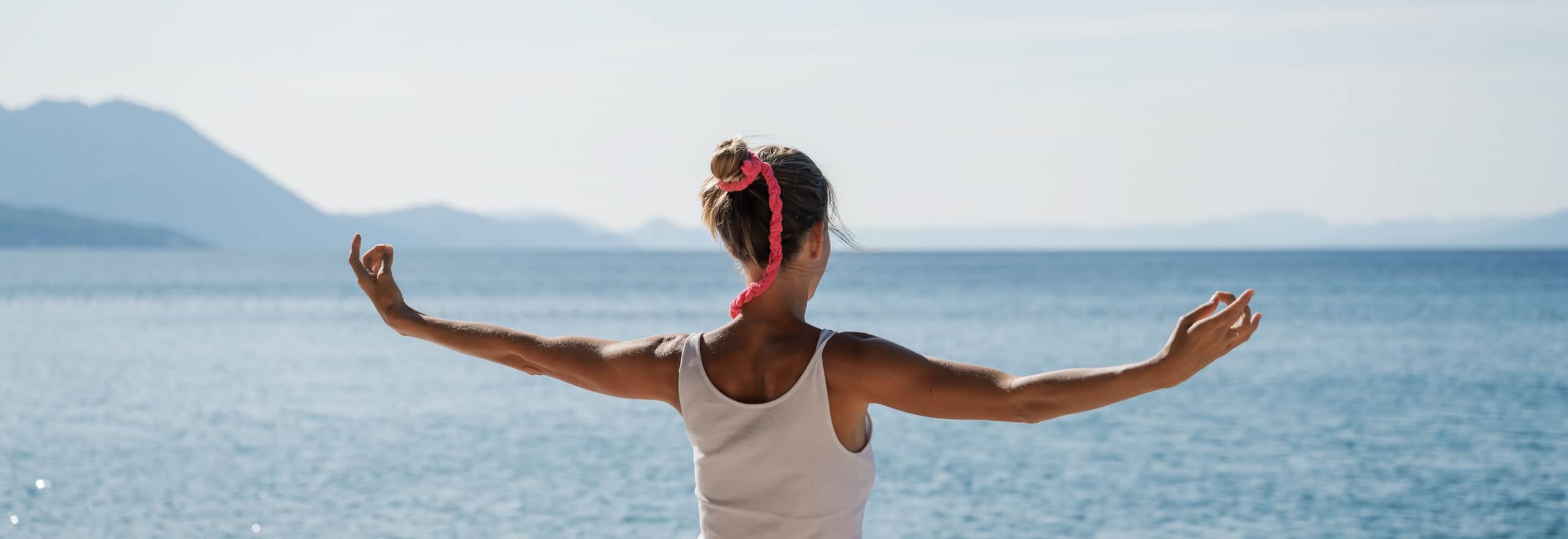 Young woman morning meditation by the sea