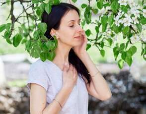 person doing some breathwork outside with hand on heart