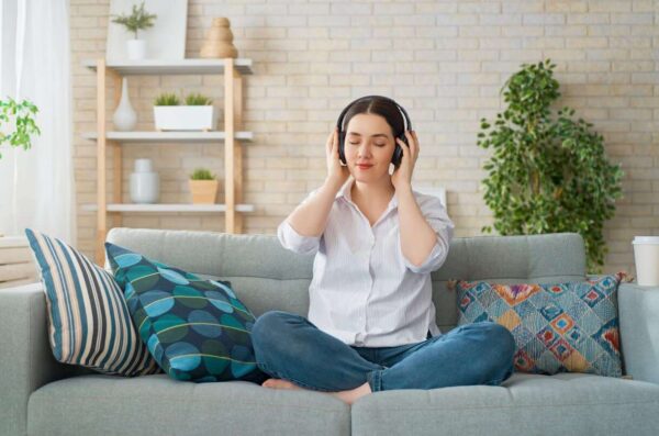 person with headphones on couch learning about brainwaves and sleep