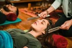 people laying down to listen to tuning forks for crown chakra balancing