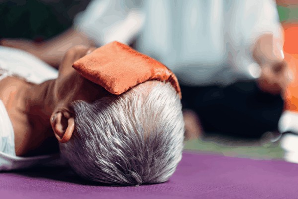 person using a dried lavender filled eye pillow used for relaxation and meditation