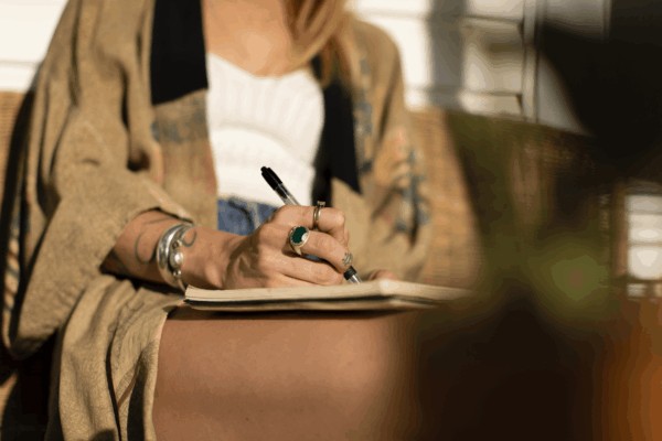 person writing in their Meditation journal open for daily reflection