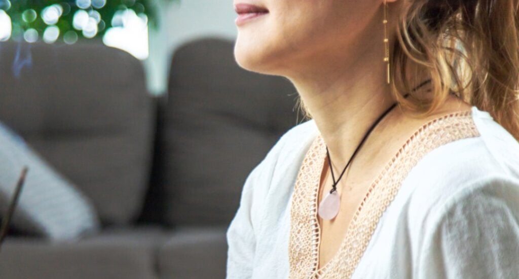 person wearing rose quartz pendant