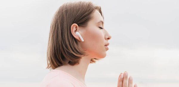 person listening to chakra meditation music through earphone