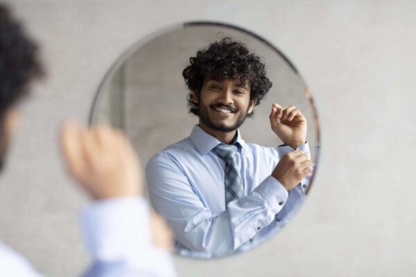 person looking at themselves in mirror and smiling
