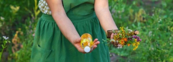 hands holding flowers and an essence bottle