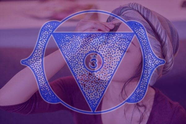 person activating third eye chakra with a crystal