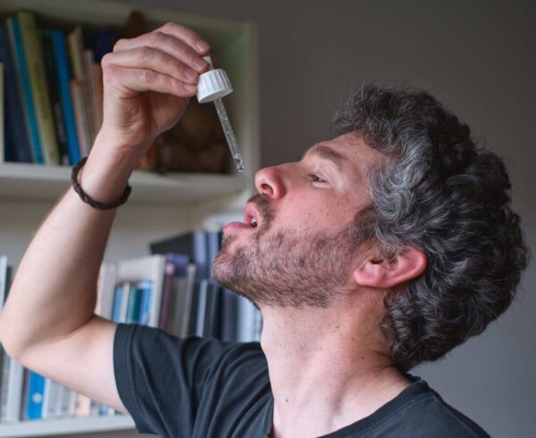 person taking in some drops of bach flower essences