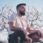 bearded man meditating in spring garden
