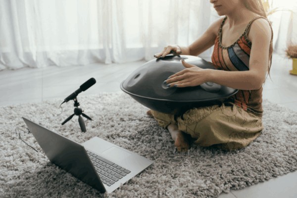 meditation teacher using hangdrum infront of her online class