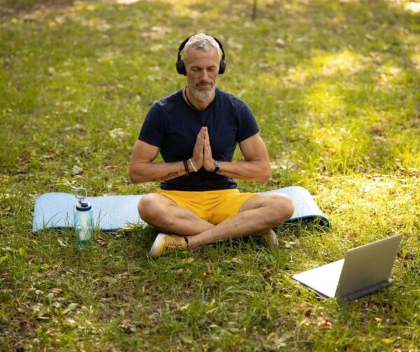person outdoors listening to meditation music using headphones