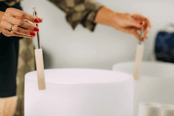 person playing crystal quartz singing bowl