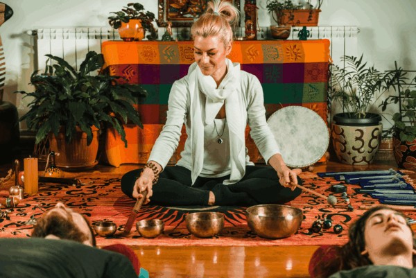 person playing meditation instruments for a sound bath experience