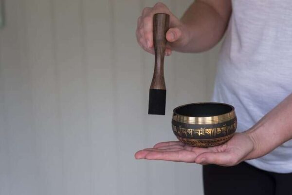 person playing tibetan singing bowl