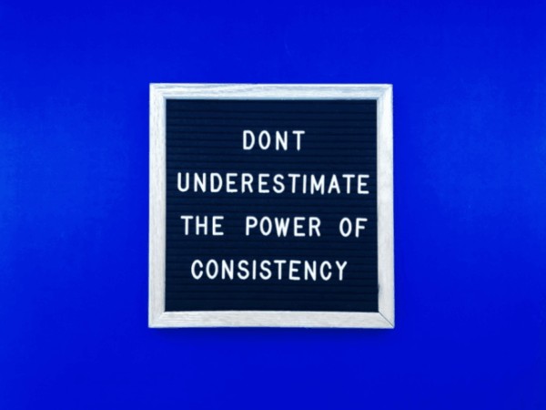 quote on blue background saying dont underestimate the power of consistency